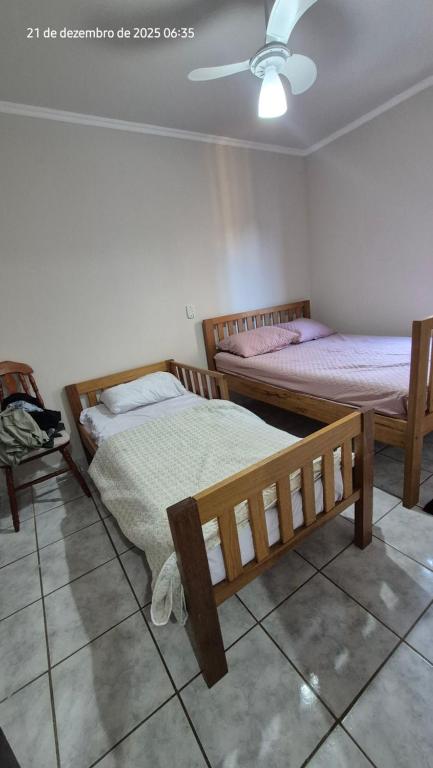 una camera da letto con due letti e un ventilatore a soffitto di Apartamento à 5min à pé da Praia a Ubatuba