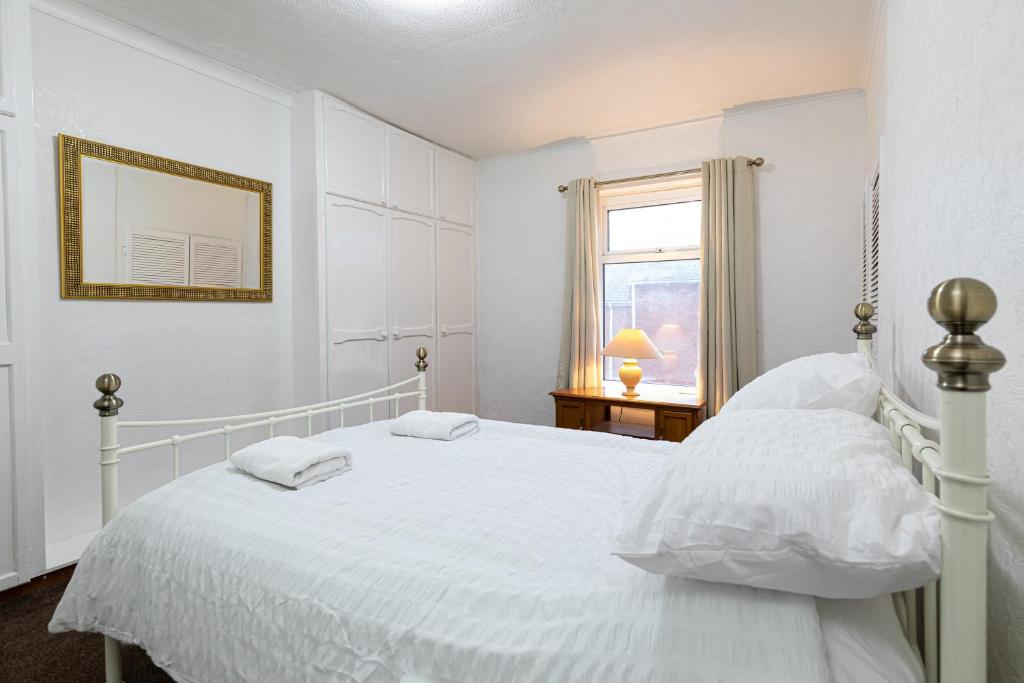 a white bedroom with a white bed and a window at Beamish Museum Retreat in Chester-le-Street