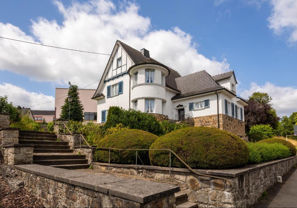 ein weißes Haus mit einer Treppe davor in der Unterkunft Villa Vulkaneifel in Kelberg