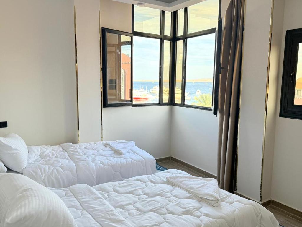 two beds in a room with a window at VERO Residence in Hurghada