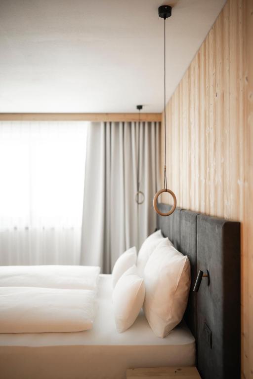 a bedroom with two beds with white pillows and a window at LA TRUGA Suite Apartments in Selva di Val Gardena