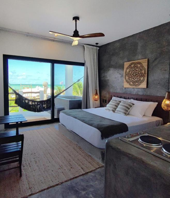 a bedroom with a bed and a large window at Casa del Mar Holbox in Holbox Island