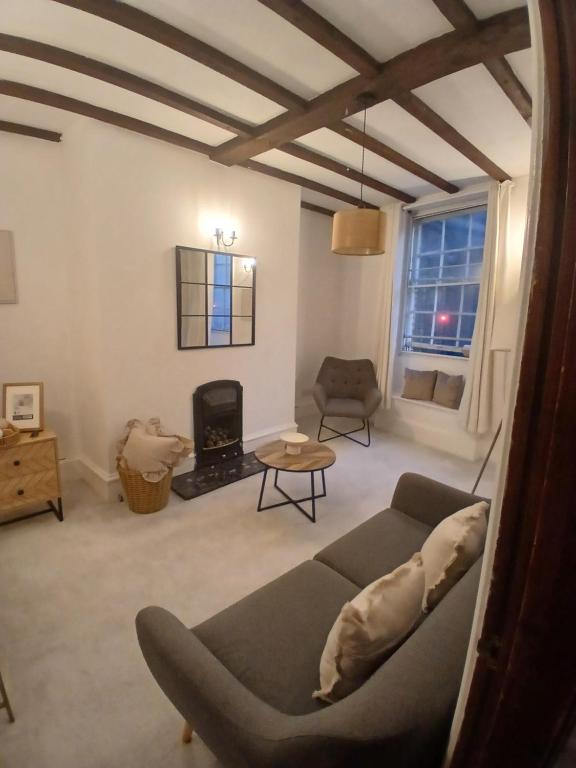 een woonkamer met een bank en een open haard bij Central Bewdley - Load Street Retreat in Bewdley