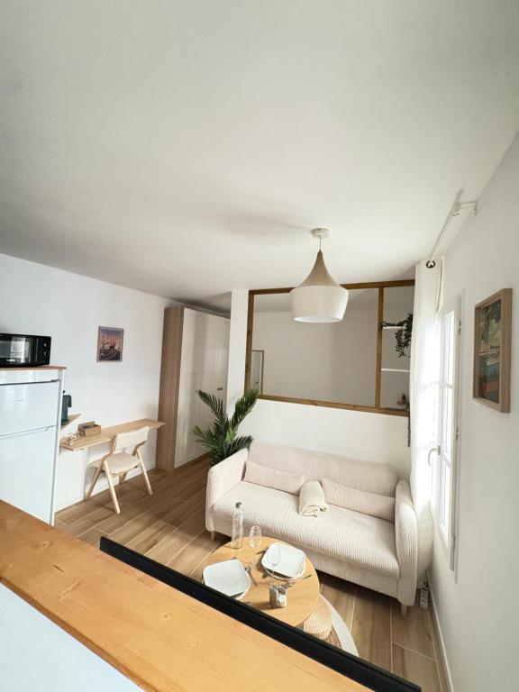 een woonkamer met een bank en een tafel bij L'impasse Japandi in Libourne