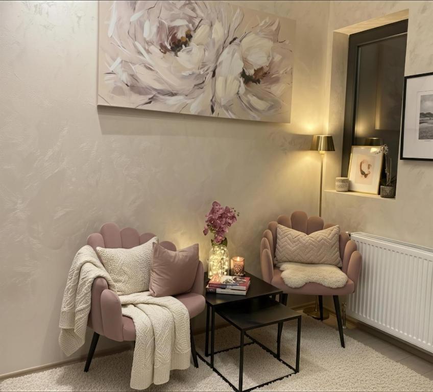 a living room with two chairs and a table at ELLA LUX APARTMAN Čačak in Čačak