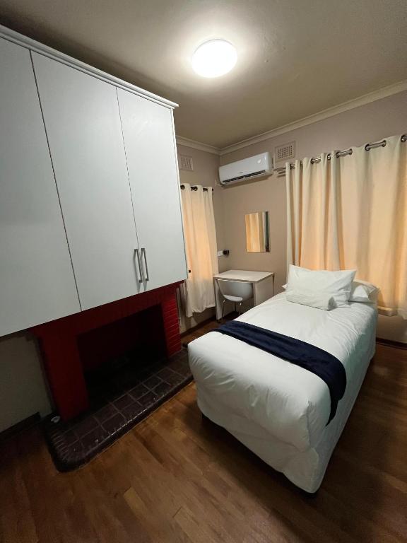 una camera con un letto e un grande armadio bianco di Crème de la crème a Durban