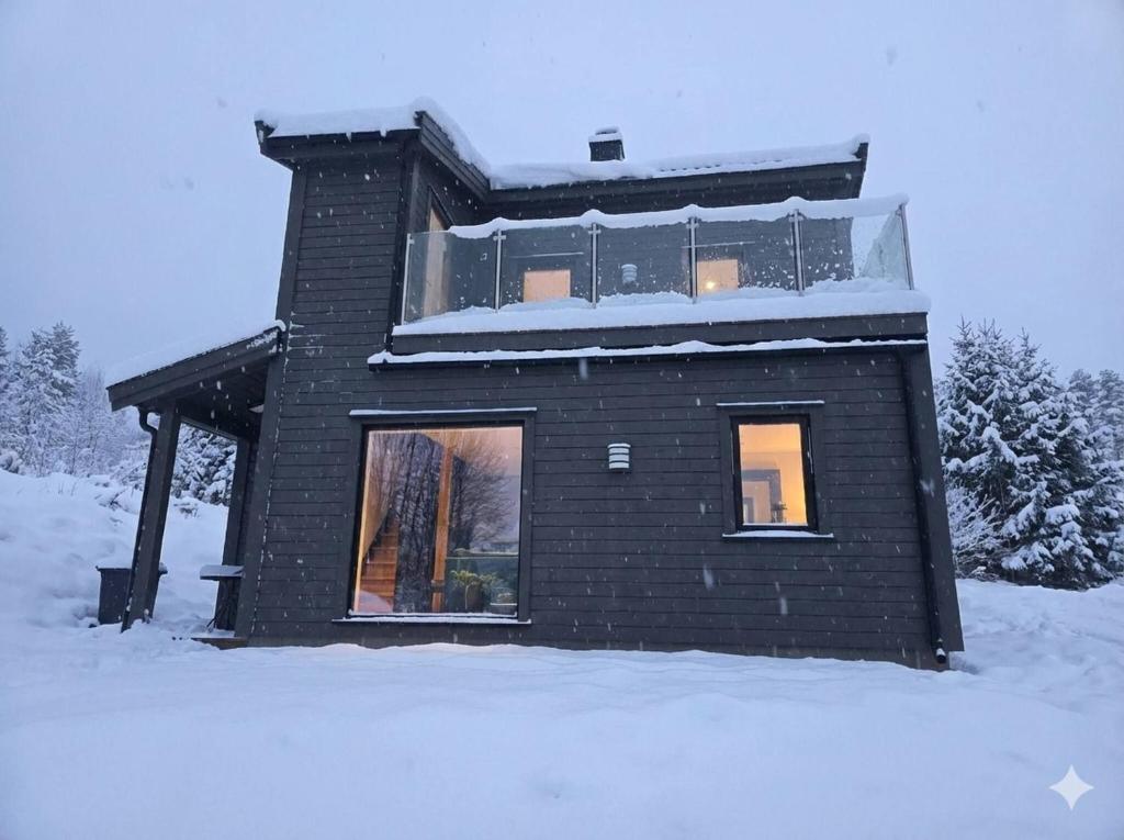 een zwart bakstenen huis in de sneeuw bij House with great location in Trysil