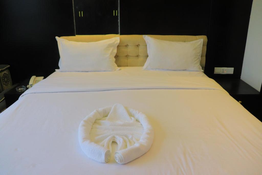 Al Jardāʼفندق غلاديلاس的白色的床和白色毛巾
