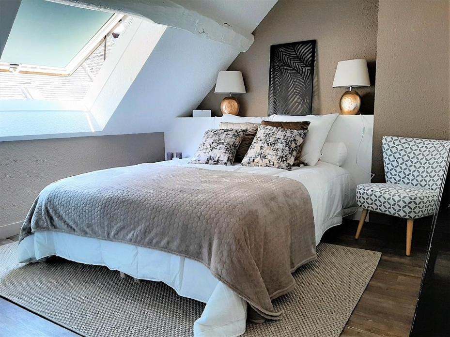 een slaapkamer met een bed, een raam en een stoel bij O paradis in Beaune