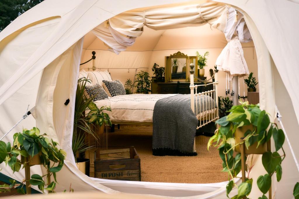 ein Schlafzimmer mit Himmelbett und Topfpflanzen in der Unterkunft Victoria Plum in Cropthorne