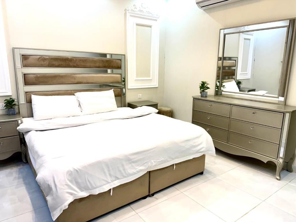 een slaapkamer met een groot bed en een spiegel bij شاليهات ميرا in Taif