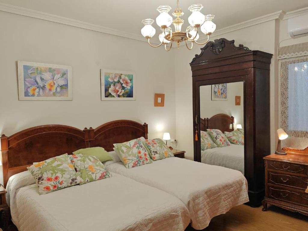 een slaapkamer met 2 bedden en een kroonluchter bij VIRGEN de ALFILERITOS in Toledo