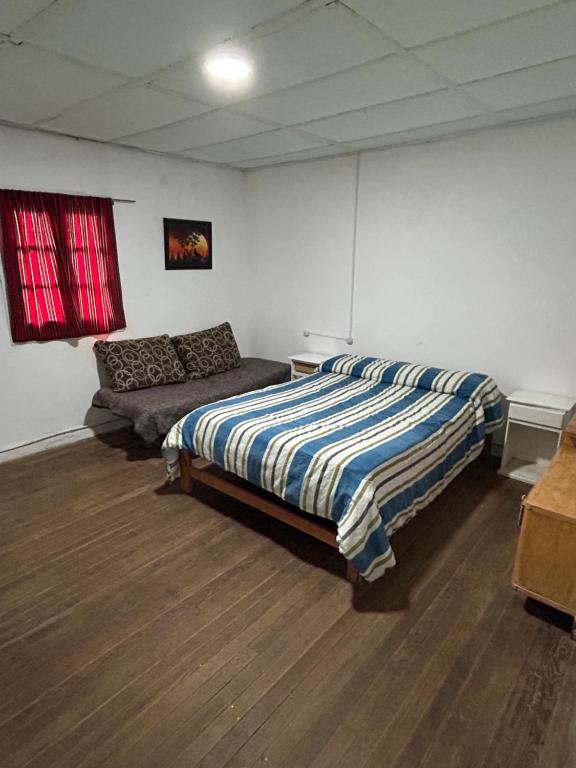 een slaapkamer met een bed en een bank erin bij Casa in Miramar