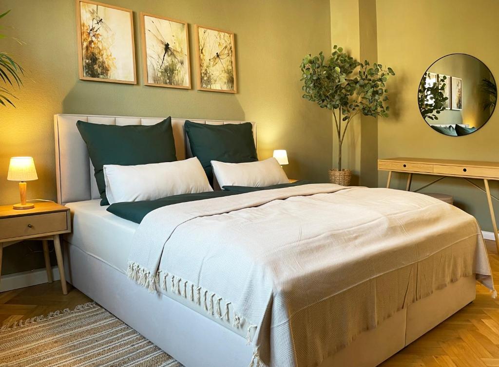 ein Schlafzimmer mit einem großen weißen Bett und einem Spiegel in der Unterkunft green rooms in Schweinfurt