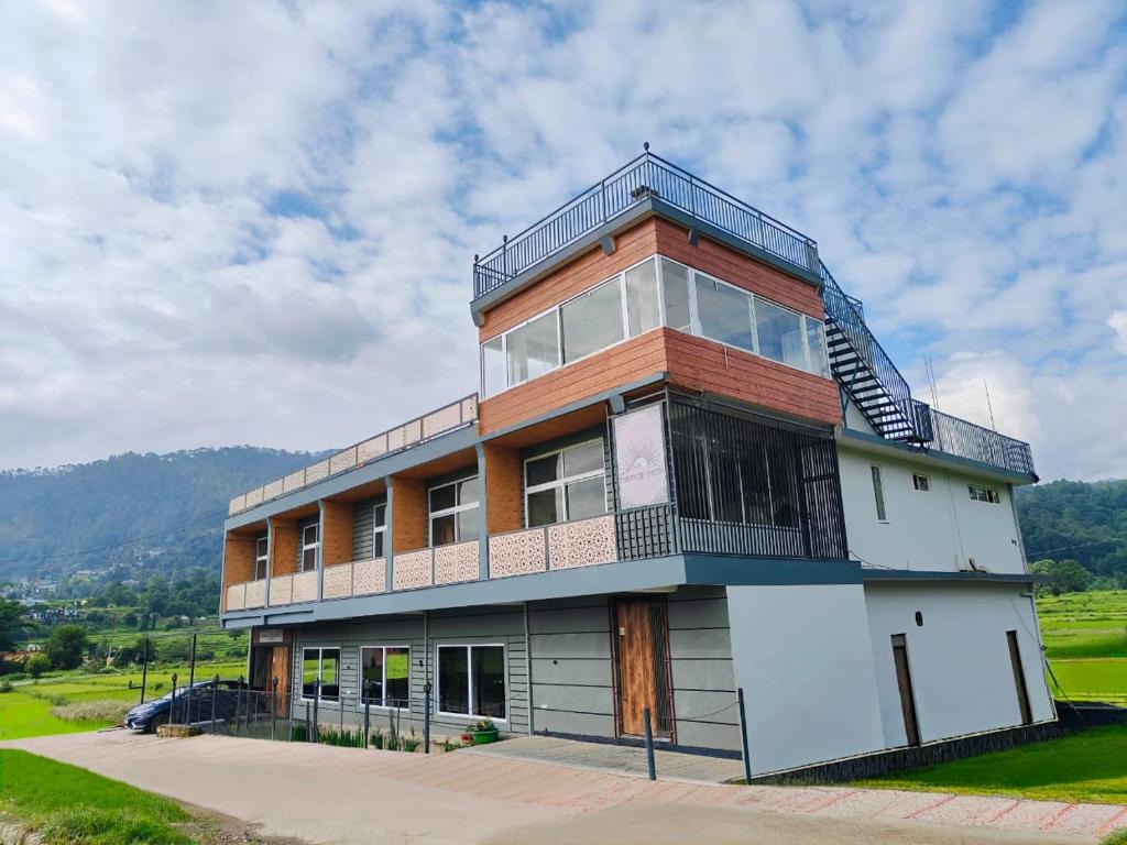 a building with a balcony on top of it at Sunrise Vista Resort & Hotel in Bāgeshwar