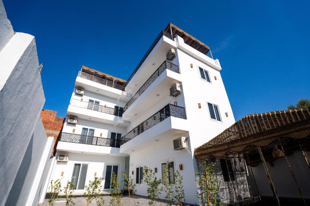 a white building with black balconies and a blue sky at Villa Ramses in Luxor