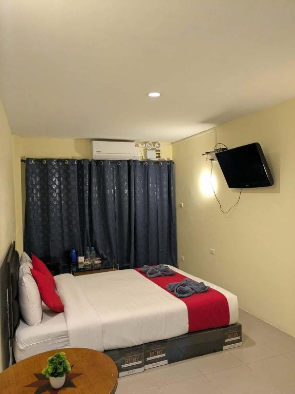 a bedroom with a bed and a tv on the wall at Number 1 Guesthouse in Ao Nang Beach