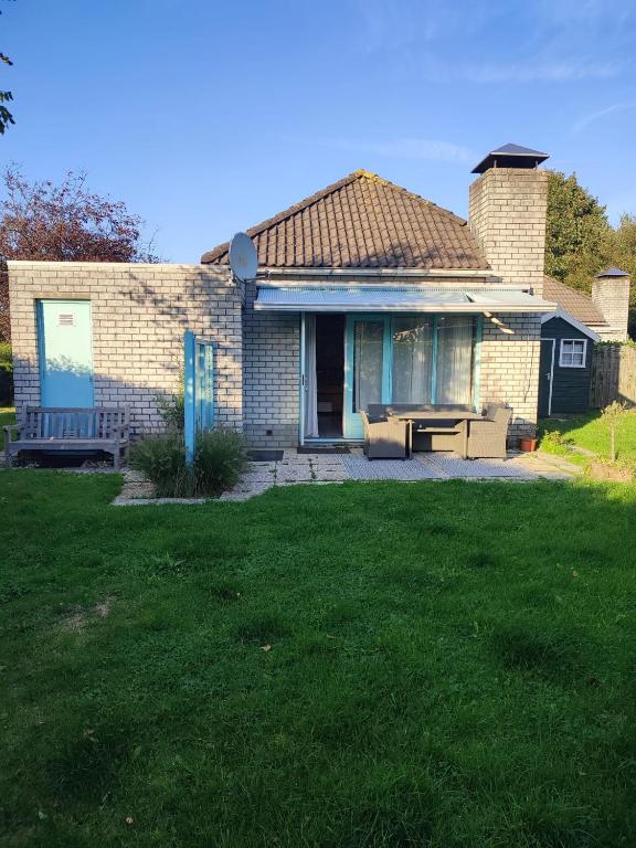 una casa in mattoni con una panchina nel cortile di Gemütliches, komfortables Ferienhaus a Schoorl