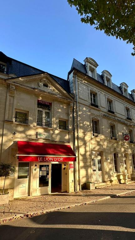 a building with a red awning in front of it at BRIT HOTEL Le Lion d'Or CHINON in Chinon