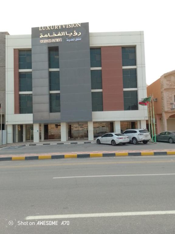 un bâtiment avec des voitures garées devant une rue dans l'établissement رؤيا الفخامة luxury vision, à Al Khafji