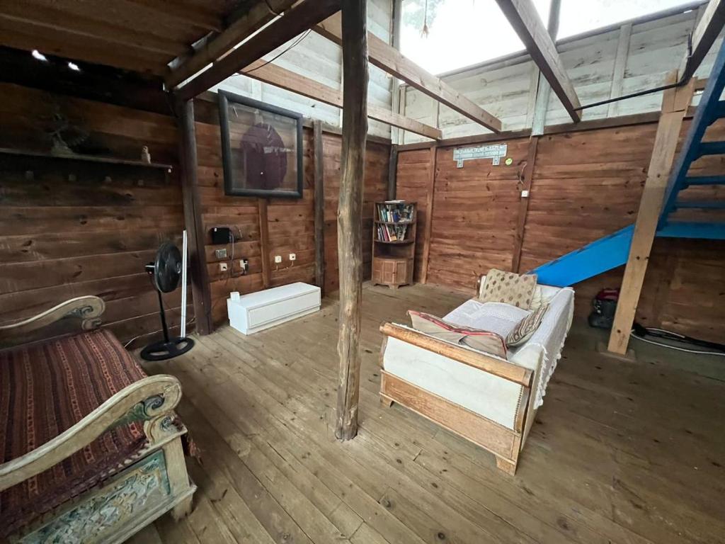 a living room with a couch and a tv in a cabin at Chalé da Joaquina in Florianópolis