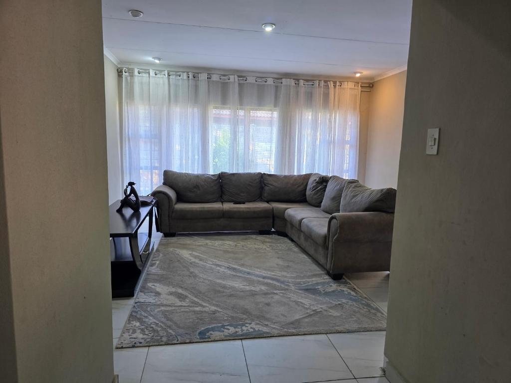 un soggiorno con un divano e un tappeto di 55 on 5th a Lichtenburg