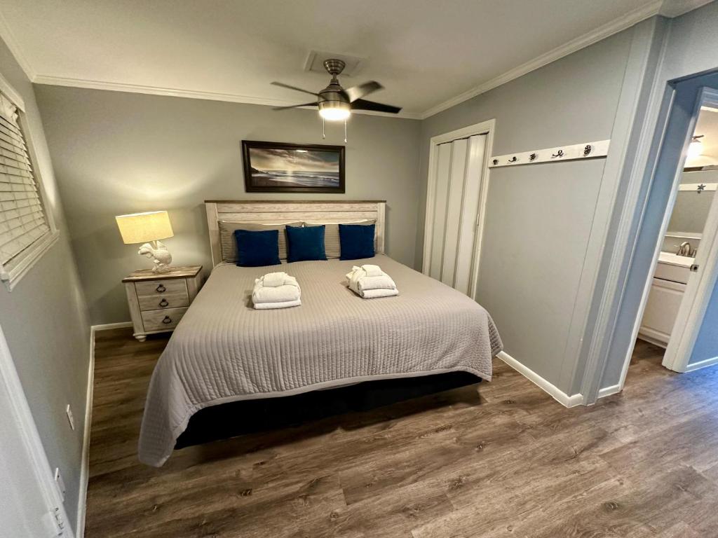 une chambre avec un grand lit avec des oreillers bleus dans l'établissement Seaside 155, à Île de Hilton-Head