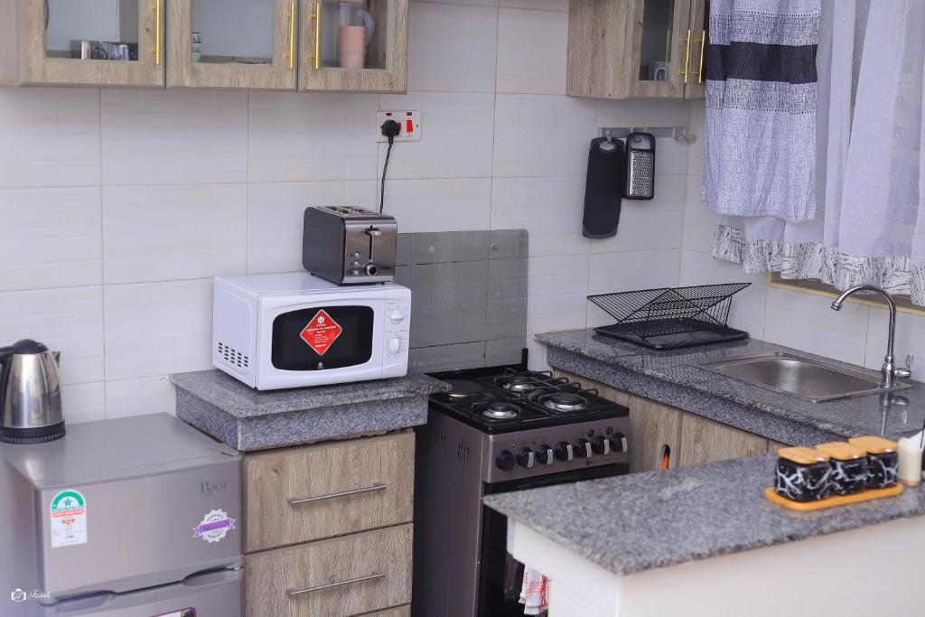 a kitchen with a microwave on top of a stove at Kj suites in Meru
