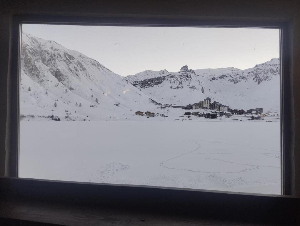 a window with a view of a snow covered mountain at Van a louer au pied des pistes 2 in Séez