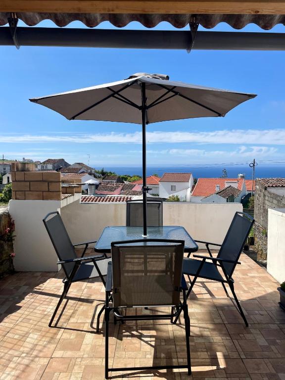 a table and chairs with an umbrella on a patio at Santana Northeast in Feteira Grande