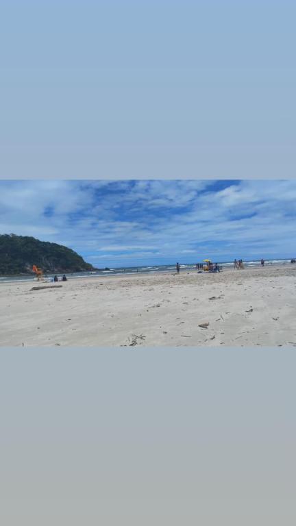 two pictures of a beach with people on it at Casa Aconchegante in Bertioga