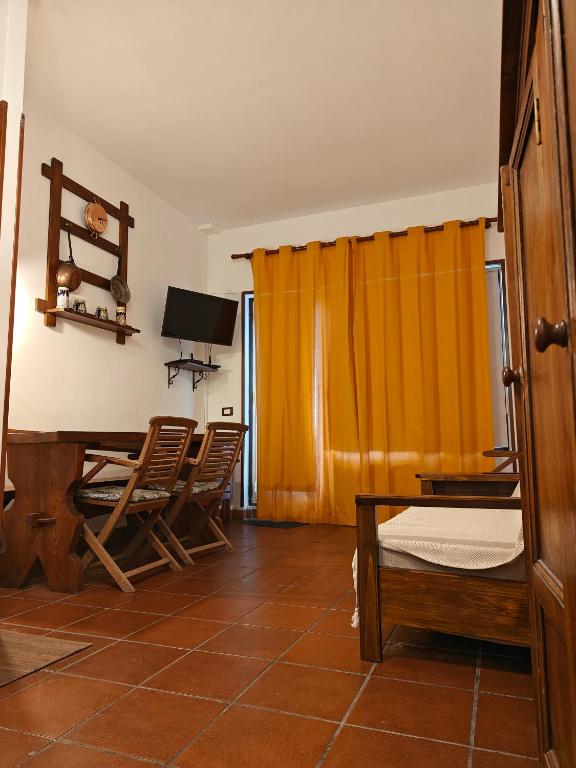 a room with a table and chairs and a television at Appartamento Rialto Terminillo in Terminillo