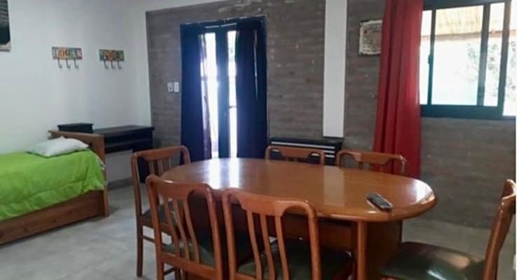 een kamer met een tafel en stoelen en een bed bij Verano Paz in Villa Carlos Paz