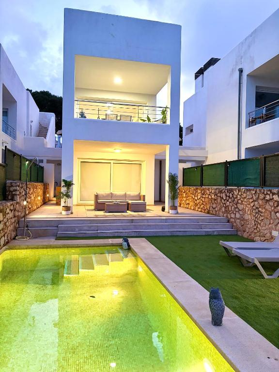 a house with a swimming pool in front of a house at Chalet Barceló Rocher in Cala d´Or