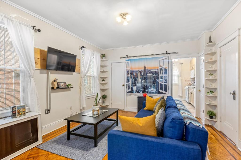 a living room with a blue couch and a tv at Impeccable 1BR unit in Brooklyn in Brooklyn