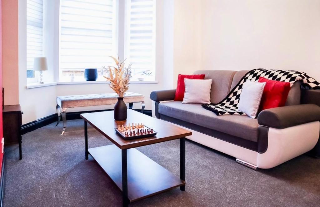 a living room with a couch and a table at Cosy Luxe Manchester Home With Fresh Bakes in Manchester