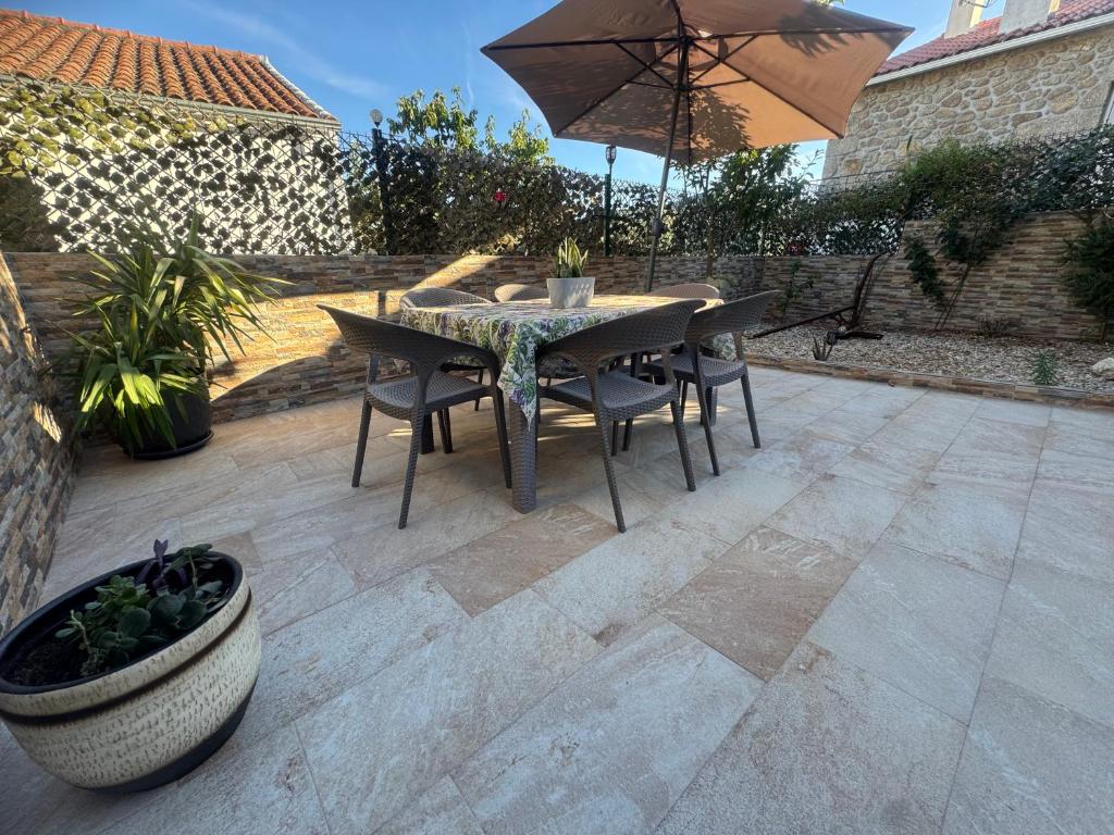 a table and chairs with an umbrella on a patio at Sofiamarholidays O Cantinho da Avó Bina in Moita