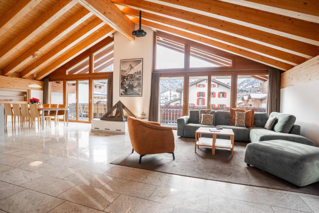 a living room with a couch and a fireplace at Turuwang Penthouse by HomeFlow in Zermatt