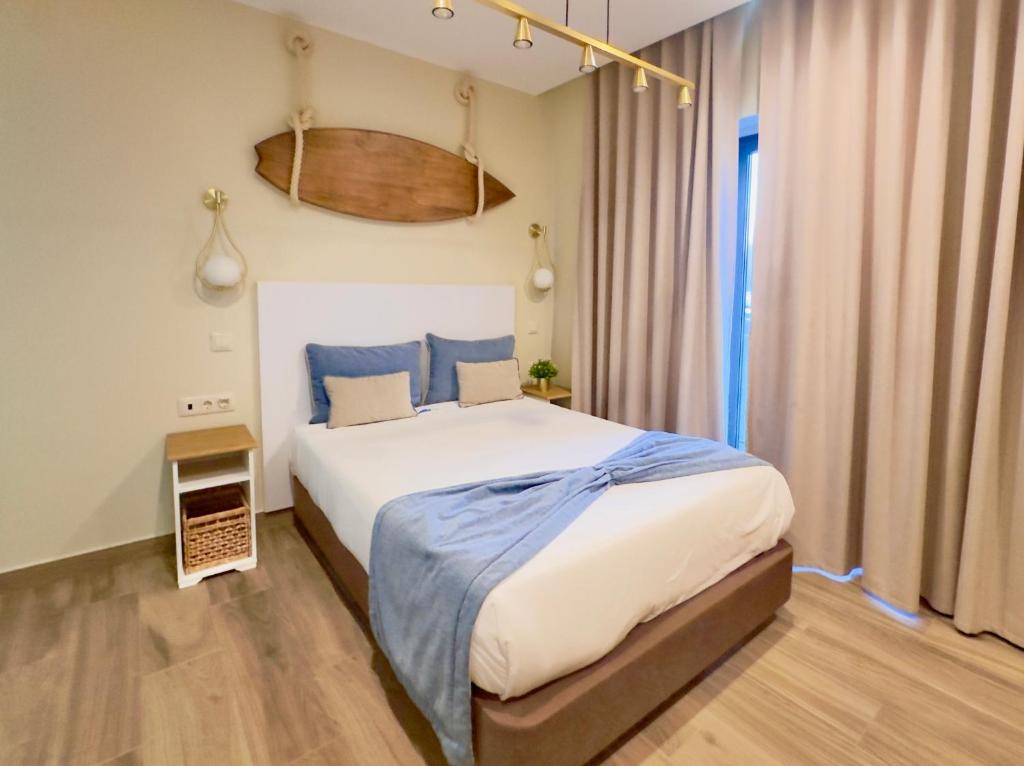 a bedroom with a large bed with blue pillows at Na Crista da Onda in Nazaré