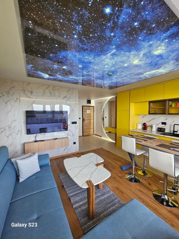 a living room with a blue couch and a table at Apartman Blue Sky in Jahorina