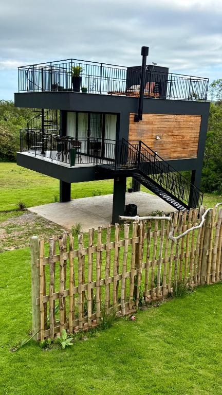 ein Haus mit einem Holzzaun davor in der Unterkunft Cabanas do Platô in Praia Grande
