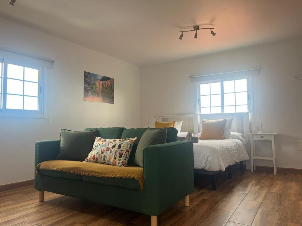 ein Wohnzimmer mit Sofa und Bett in der Unterkunft Los Frailes 2 in Breña Baja