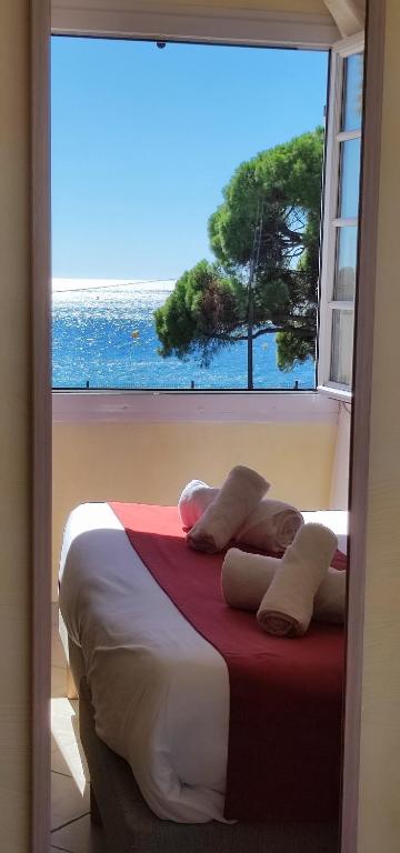 a bedroom with a bed with a large window at Hôtel & Spa La Villa in Sainte-Maxime