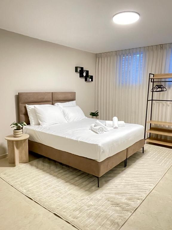 een slaapkamer met een groot bed met witte lakens bij Ramon Palms in Mitzpe Ramon