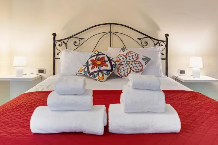 una camera con letto rosso e bianco con cuscini di Residenza Amé Peschiera del Garda a Peschiera del Garda