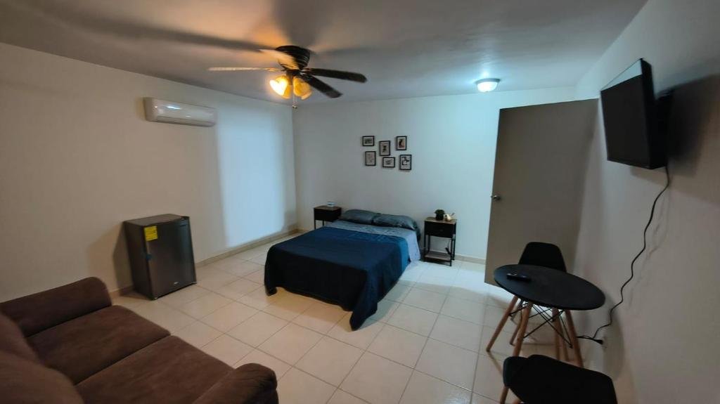 een woonkamer met een bed en een bank bij Santafe Minisuites in Hermosillo