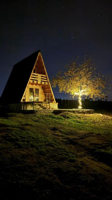 Eine Scheune mit einem Baum auf einem Feld bei Nacht in der Unterkunft Chalé da Cumieira Nova in Seia
