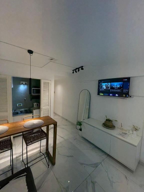 un salon avec une table et une télévision au mur dans l'établissement Monoambiente en el corazón de barrio sur, à San Miguel de Tucumán