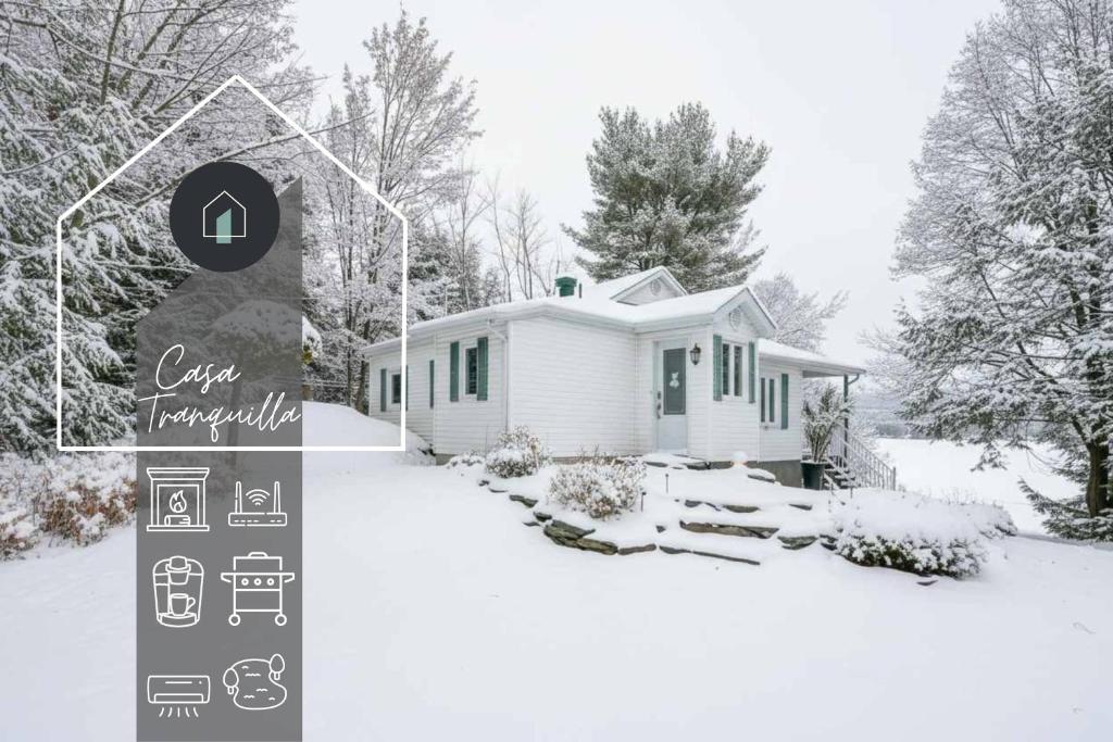 een klein wit huis in de sneeuw met bomen bij La Tranquilla - calm & comfort in Eastman