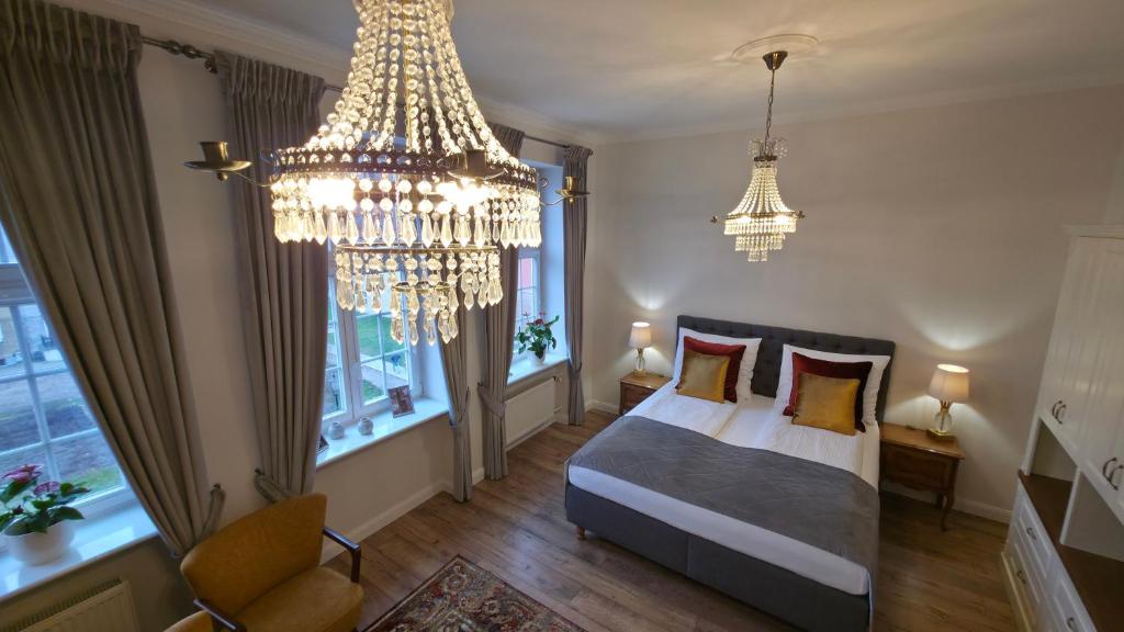 Olives Marina Apartment Old Town Gdańsk في غدانسك: غرفة نوم بسرير وثريا